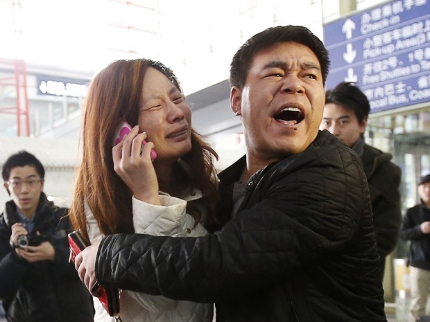 Parente de passageiro do voo MH370 da Malaysia Airlines chora enquanto fala no celular no Aeroporto Internacional de Pequim, China, neste sábado (8). O voo que ia de Kuala Lumpur a Pequim, na China, está desaparecido. Aeronave levava 239 pessoas a bo